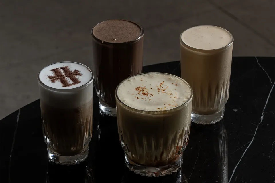 Three coffees with the Link Lounge monogram drawn in the foam