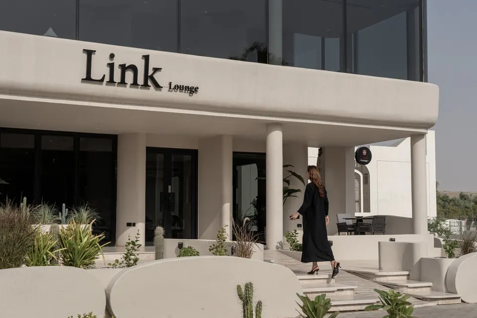 A guest walking past the Link Lounge façade and terrace