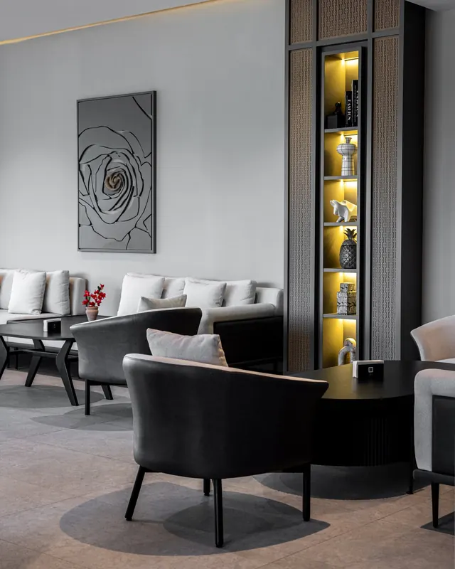 Inside Link Lounge: black chairs, marble and warm light