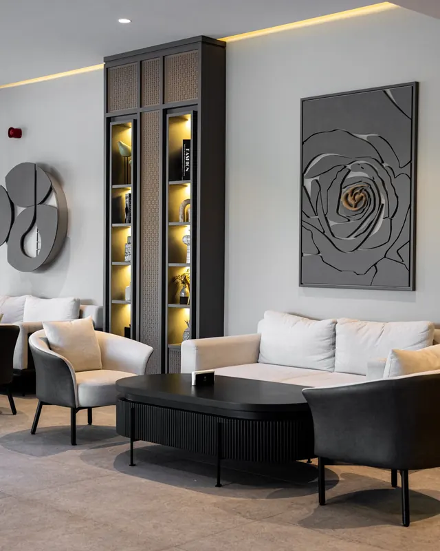 The lounge: soft chairs, a sculpted wall and lit shelves